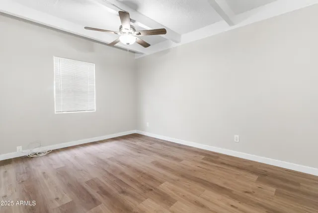 an empty room with a fan & a ceiling fan