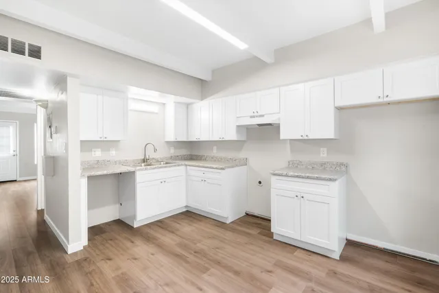a view of a kitchen with sink and dishwasher with wooden floor