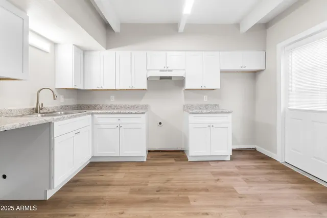 a kitchen with granite countertop white cabinets and white appliances