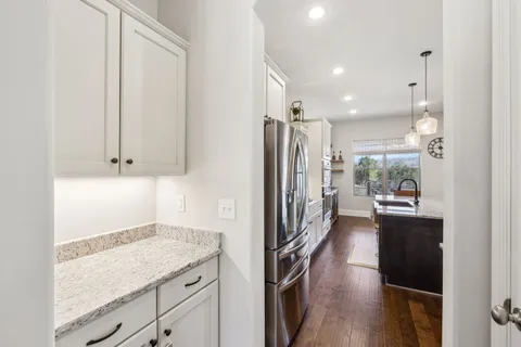 a large kitchen with kitchen island a stove a sink a oven and a chandelier