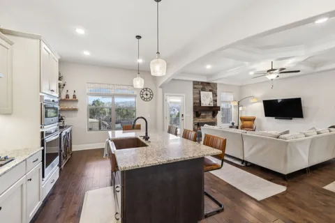 a kitchen with stainless steel appliances a dining table a stove and a wooden floors