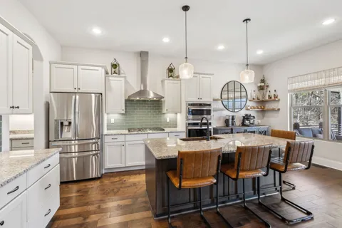 a kitchen with kitchen island a stove and a wooden floors