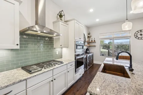 a kitchen with stainless steel appliances granite countertop a refrigerator and a sink