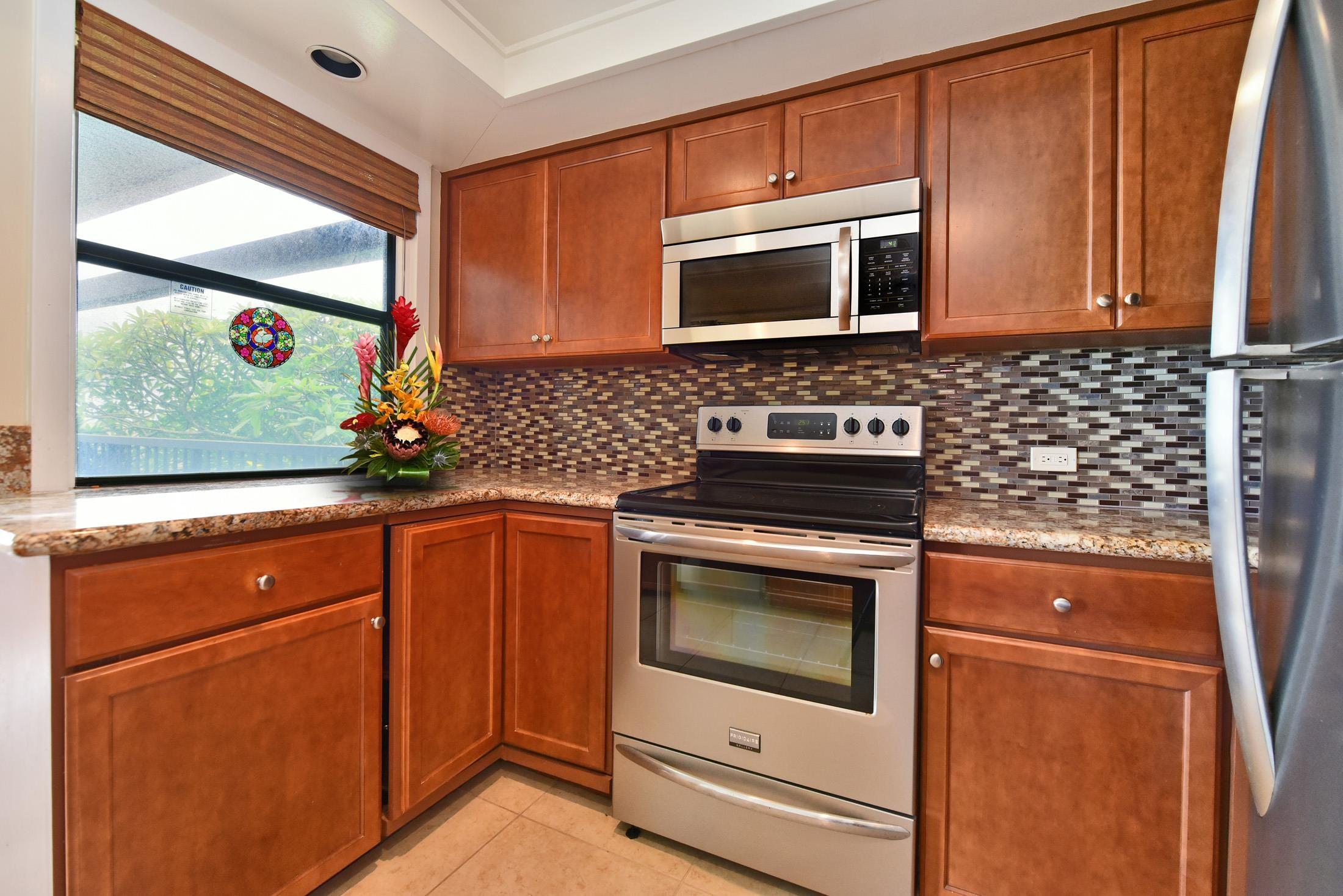 100 Ridge Road, Unit 101315 Lahaina, HI 96761 - Photo 10 of 23 a kitchen with stainless steel appliances granite countertop white cabinets and a stove