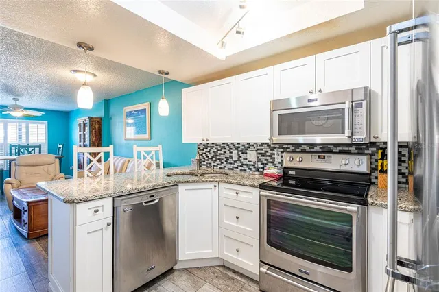 a kitchen with stainless steel appliances granite countertop a stove and a sink
