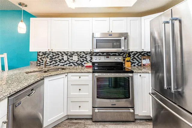 a kitchen with stainless steel appliances granite countertop a stove and a refrigerator