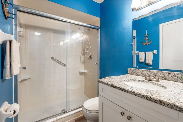a bathroom with a granite countertop sink toilet and shower