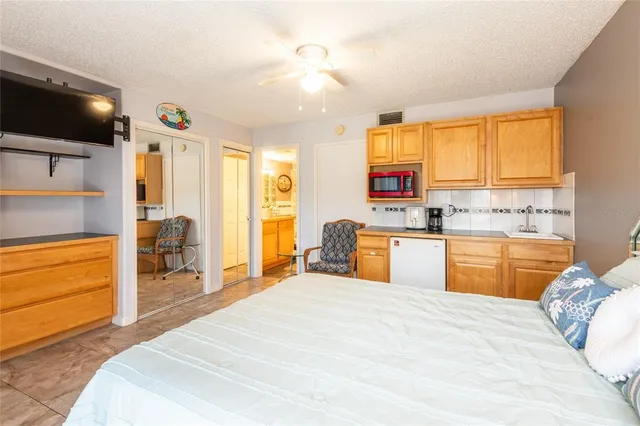 a bedroom with a bed and a view of kitchen