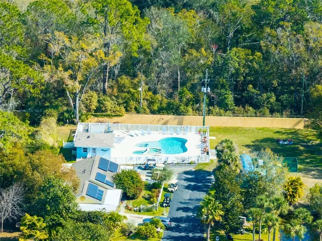 an aerial view of a residential houses with yard