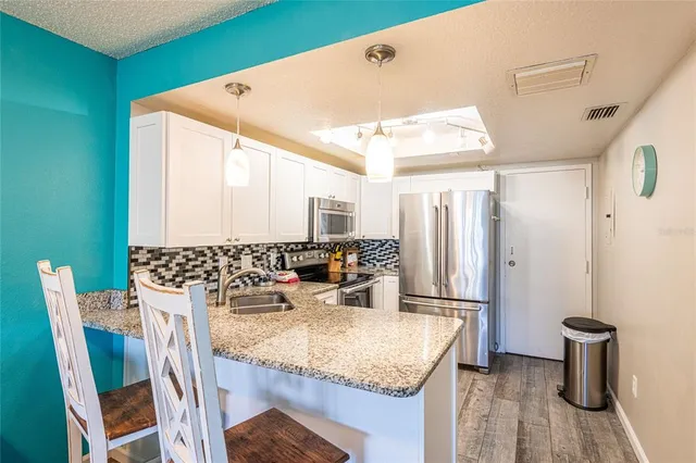 a kitchen with kitchen island a stove a sink and a refrigerator