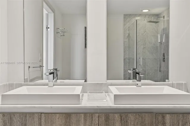 a bathroom with double vanity sinks and a mirror