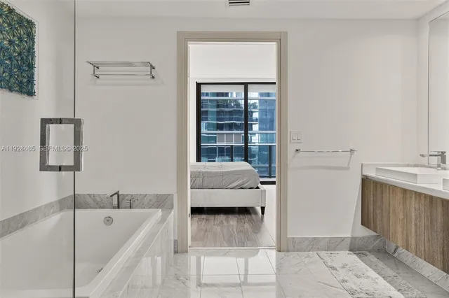 a bathroom with a tub shower and sink