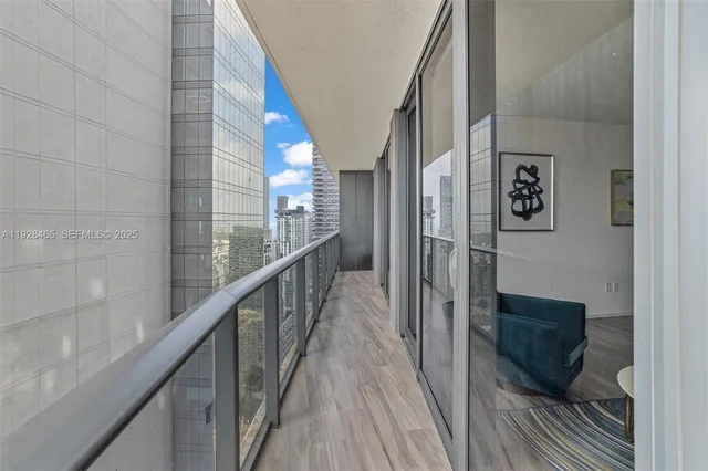 a view of balcony with a couple of cars parked in front of a house
