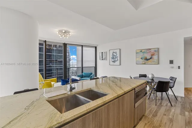 a kitchen that has a sink and a stove with wooden floor