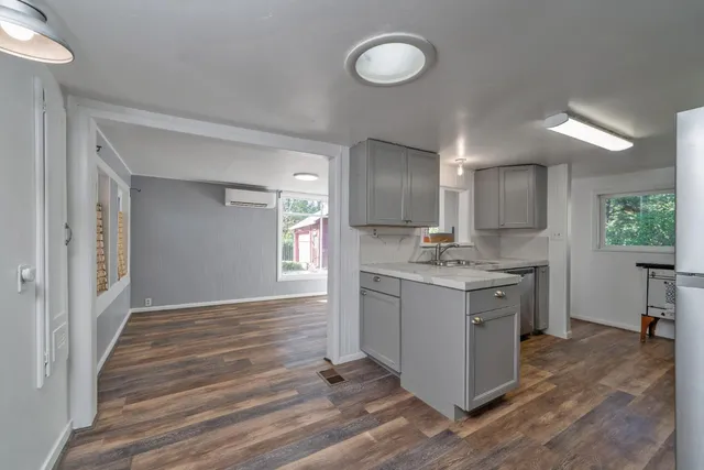 a kitchen with a sink cabinets and wooden floor
