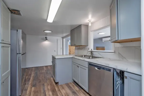 a kitchen with a sink cabinets stainless steel appliances and a window
