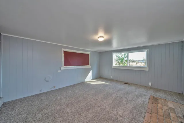 an empty room with fireplace and windows