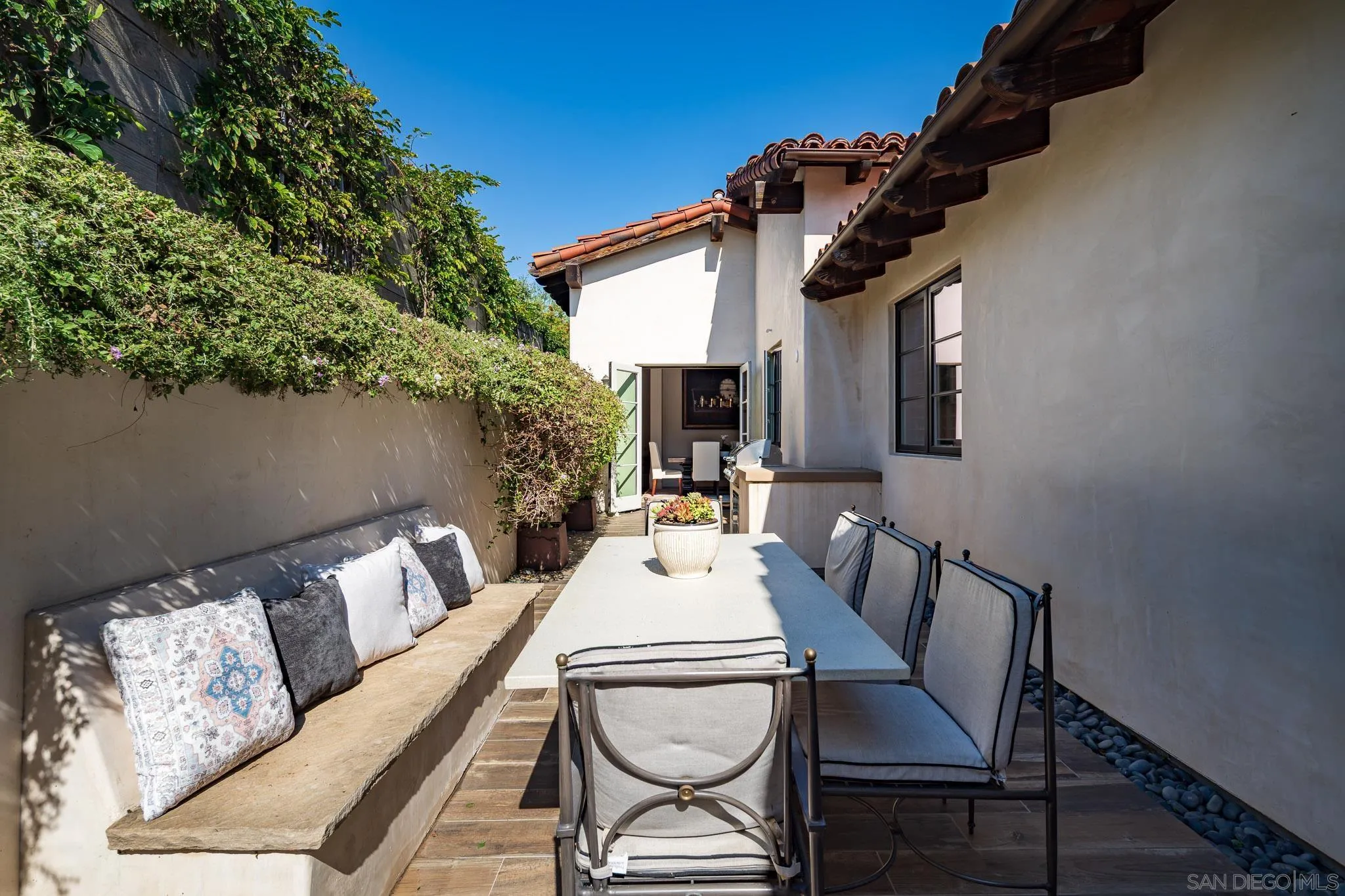 6152 Camino Selva Rancho Santa Fe, CA 92067 - Photo 23 of 37 a view of a patio with a dining table and chairs with wooden floor