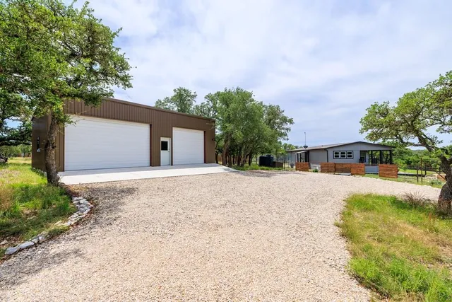a front view of a house with a yard and trees