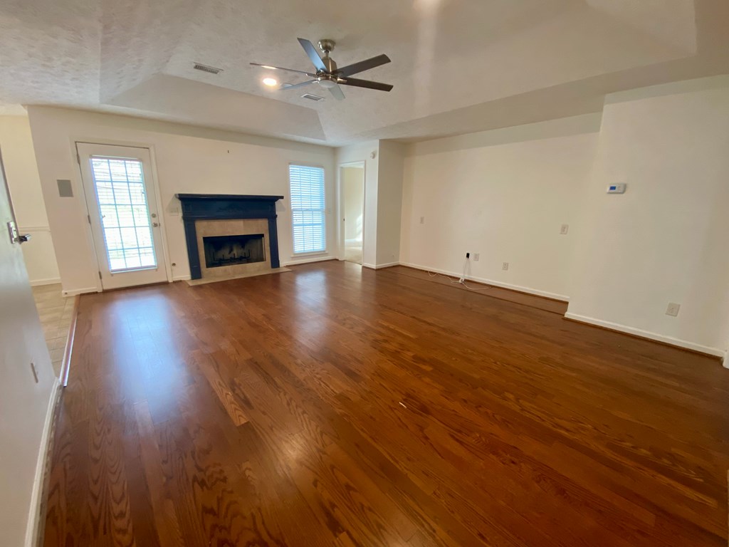 1815 Saffron Court Columbus, GA 31909 - Photo 5 of 20 an empty room with wooden floor fireplace and windows