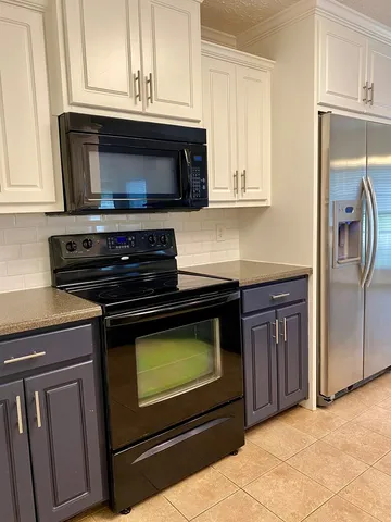 a kitchen with granite countertop a stove and a microwave