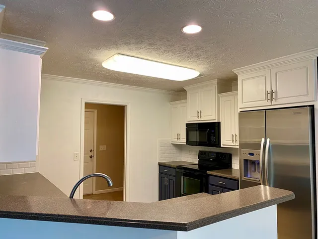 a kitchen with granite countertop stainless steel appliances and a counter space