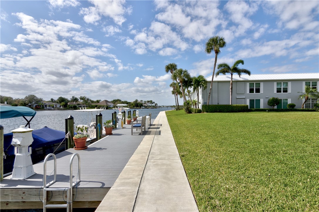 550 Riomar Drive, Unit 24 Vero Beach, FL 32963 - Photo 29 of 35 a view of a patio with table and chairs potted plants and palm trees