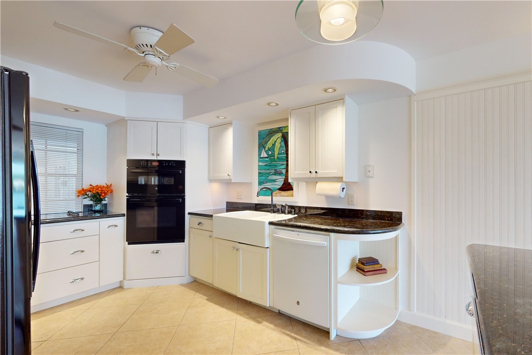 550 Riomar Drive, Unit 24 Vero Beach, FL 32963 - Photo 8 of 35 a kitchen with granite countertop a white cabinets and white appliances