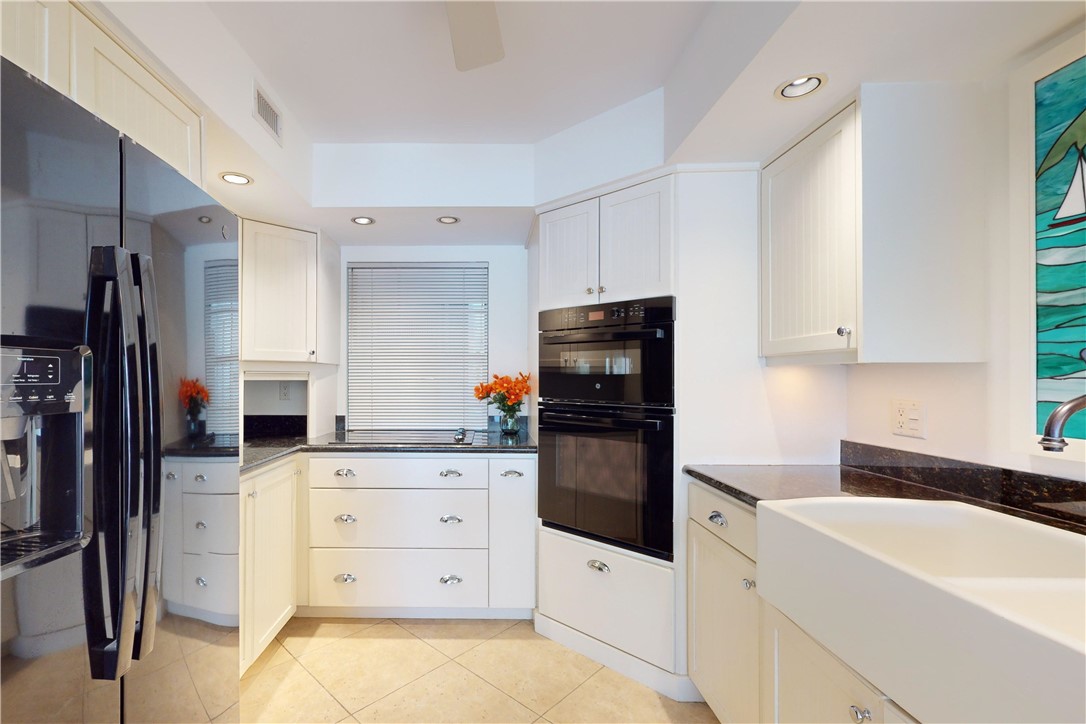 550 Riomar Drive, Unit 24 Vero Beach, FL 32963 - Photo 9 of 35 a kitchen with a refrigerator sink and white cabinets