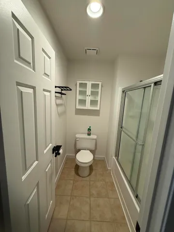 a bathroom with a sink a toilet a mirror and shower
