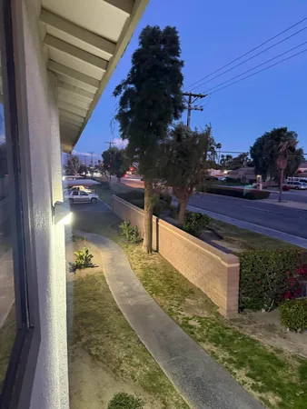 a city view with tall buildings and cars parked on the roadside