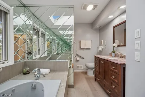 a bathroom with a tub sink and mirror