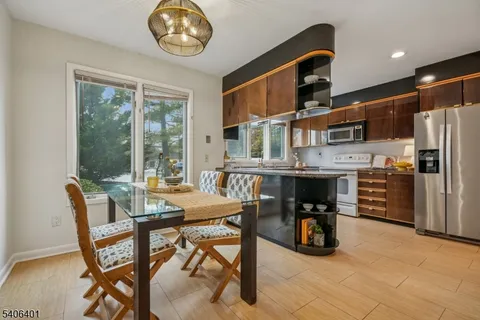 a dining room with furniture and a floor to ceiling window