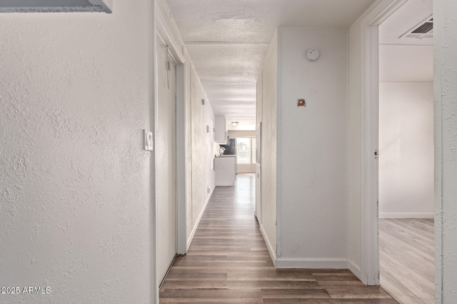 1221 North Dysart Road, Unit 35 Avondale, AZ 85323 - Photo 12 of 22 a view of a hallway with wooden floor and a bathroom