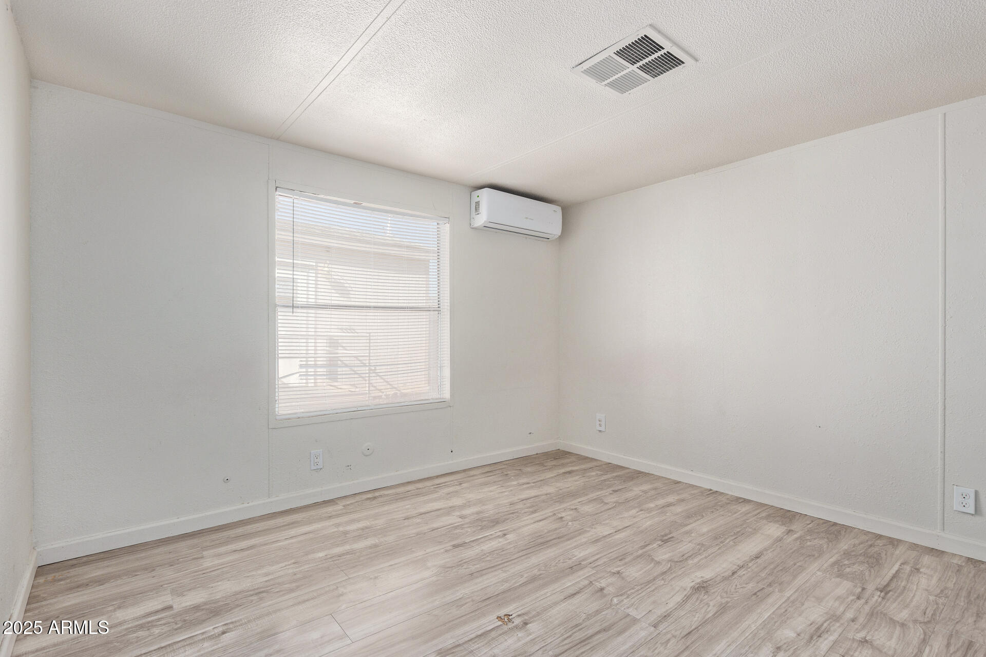 1221 North Dysart Road, Unit 35 Avondale, AZ 85323 - Photo 14 of 22 an empty room with wooden floor and windows