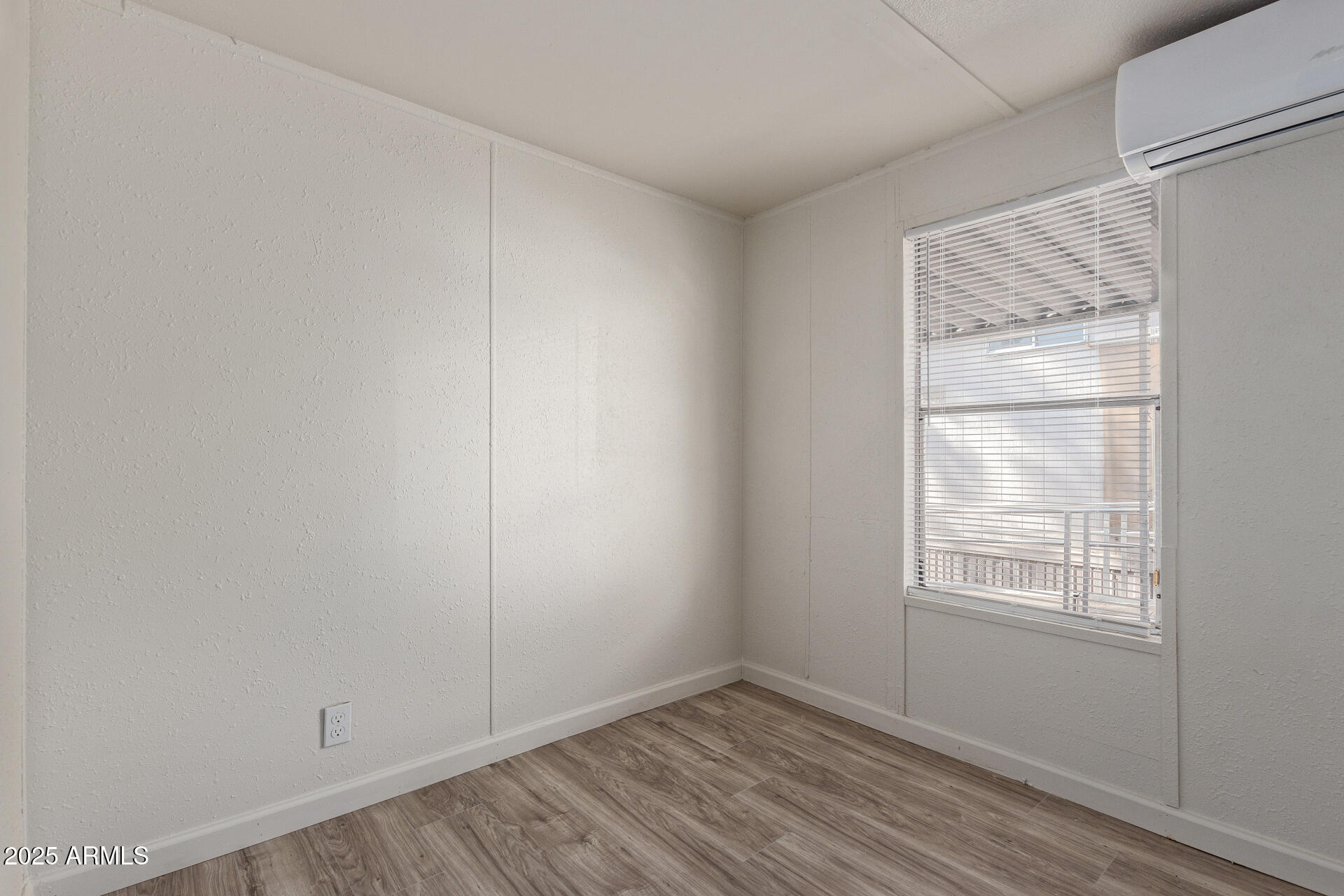 1221 North Dysart Road, Unit 35 Avondale, AZ 85323 - Photo 17 of 22 a view of an empty room with wooden floor and a window