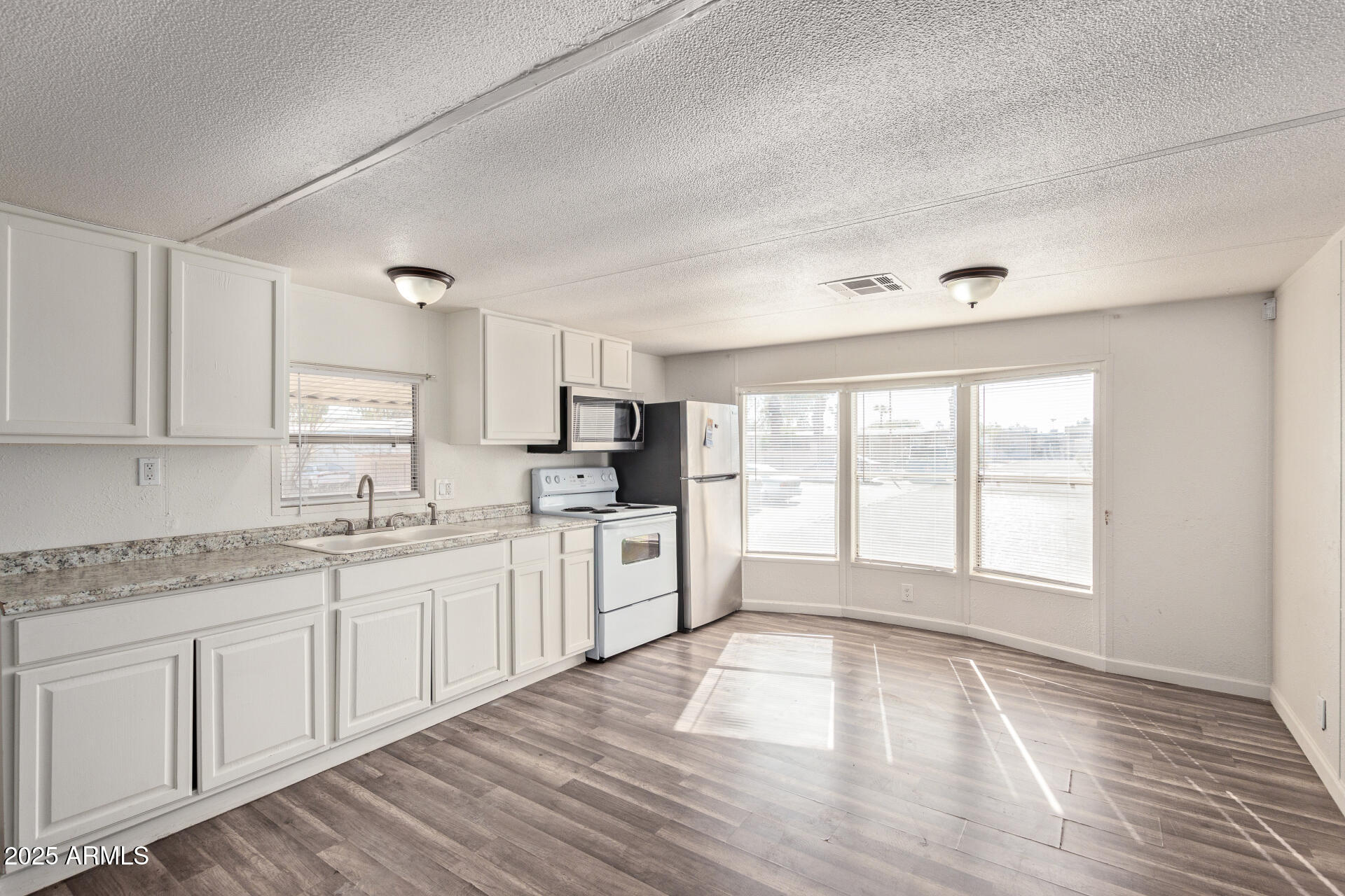 1221 North Dysart Road, Unit 35 Avondale, AZ 85323 - Photo 10 of 22 a large kitchen with cabinets and wooden floor