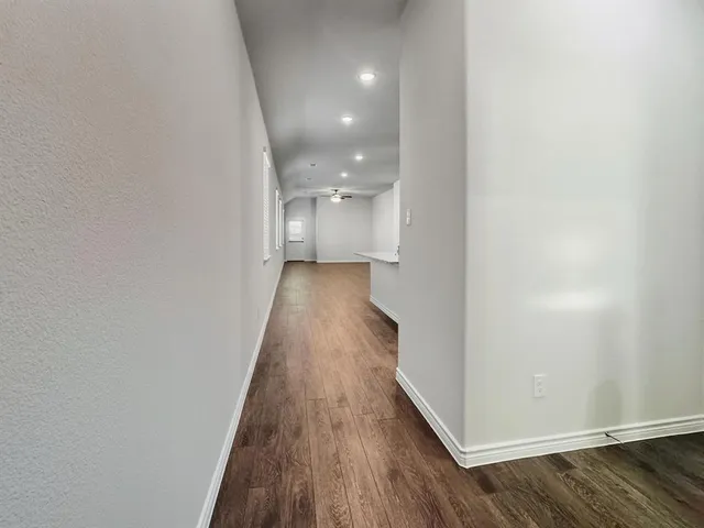 a view of a hallway with wooden floor