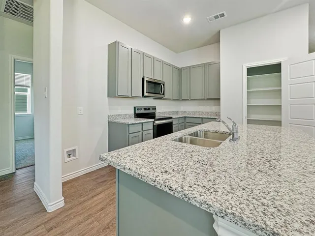 a kitchen with stainless steel appliances granite countertop a sink stove and refrigerator