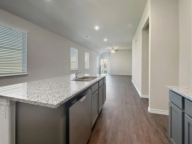 a kitchen with granite countertop kitchen island wooden floors granite counter tops and a sink