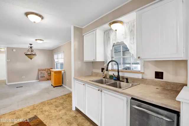 a kitchen with stainless steel appliances granite countertop a sink refrigerator and cabinets