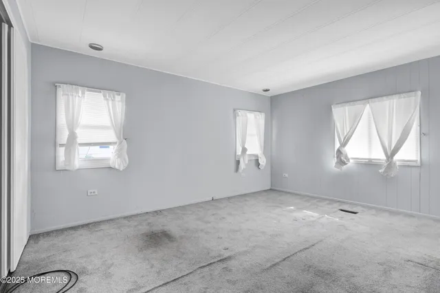an empty room with closet and windows