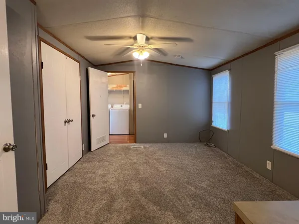en empty room with windows and fan