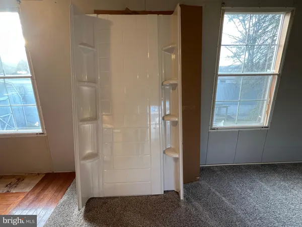 an empty room with fan and windows