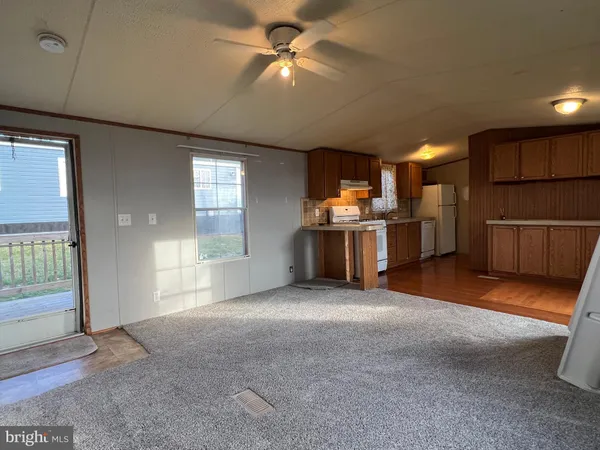 a view of a kitchen with furniture a ceiling fan and window