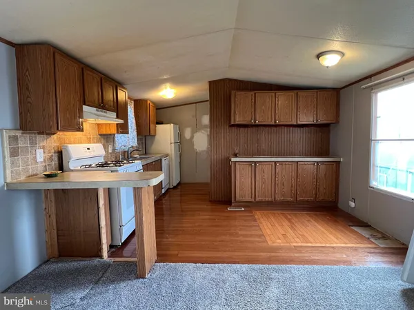 a kitchen with kitchen island granite countertop wooden cabinets a sink and a window