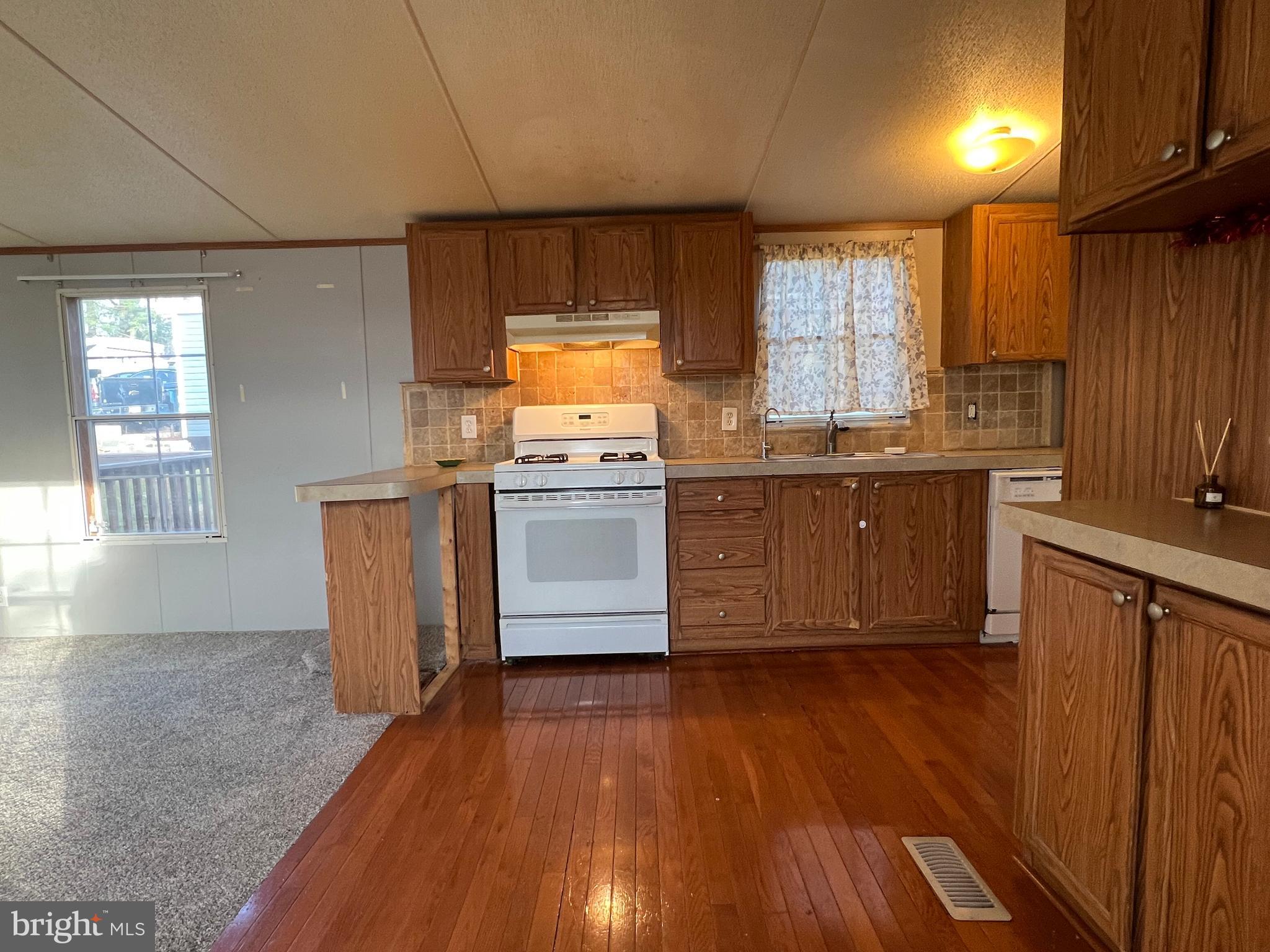4328 Ridge Road, Unit 14 Mount Airy, MD 21771 - Photo 5 of 42 a kitchen with kitchen island granite countertop wooden floors and stainless steel appliances