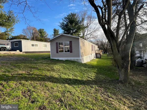 a white house that has tree in front of it