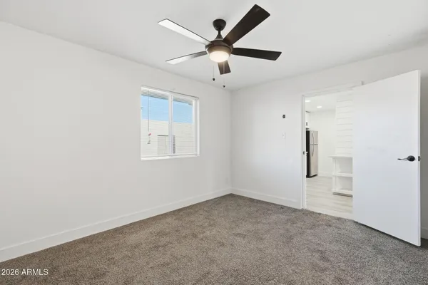an empty room with closet and windows