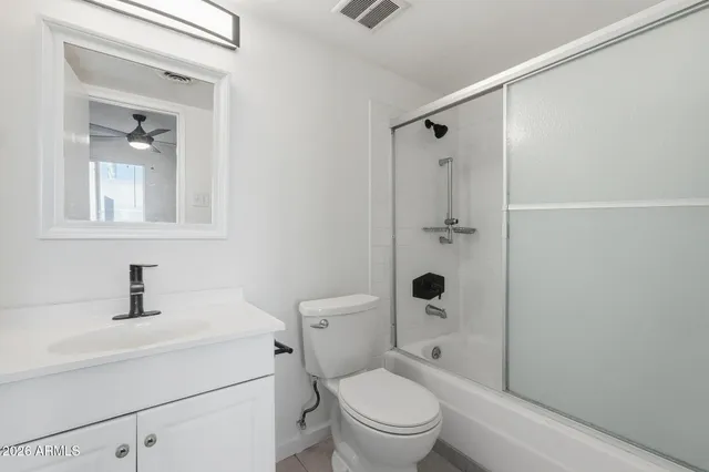 a bathroom with a toilet sink shower and mirror
